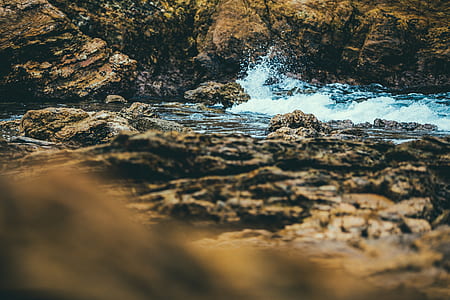 brown rock between water thumbnail