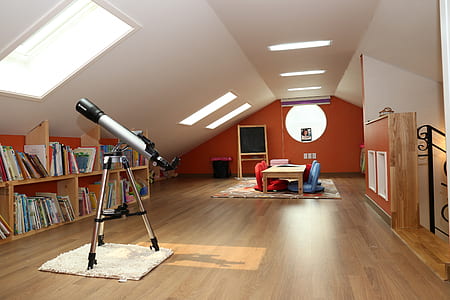 gray telescope near brown wooden book shelf thumbnail