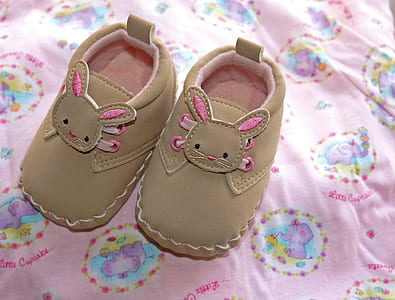 pair of infant's brown-and-pink leather crib shoes on pink and multicolored textile thumbnail