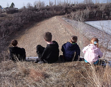 four toddler sitting on grass field facing house thumbnail