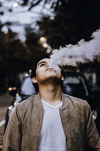 man blowing smoke on air in front of car thumbnail