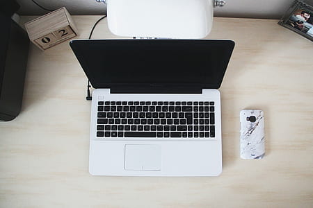 Macbook Beside Smartphone on Desk thumbnail