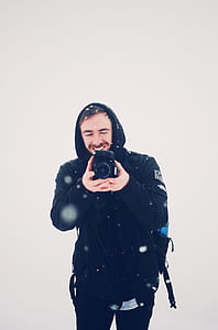 man holding camera under snow thumbnail