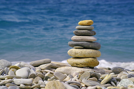 gray and black stack of stones near the ocean at daytime thumbnail