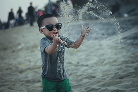 close up photo of boy wearing gray t-shirt and black framed sunglasses thumbnail
