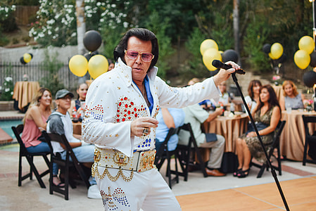 man portraying Elvis Presley holding black microphone with stand thumbnail