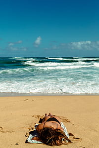 woman in black bikini sun bathing by the seashore thumbnail