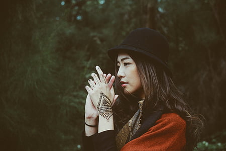 selective focus photography of woman clasping hand near green trees during daytime thumbnail