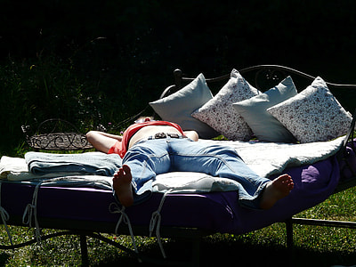 person wearing red shirt and washed blue jeans laying on bed thumbnail