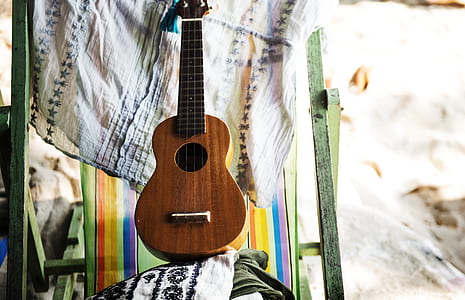 brown ukulele guitar on white textile thumbnail