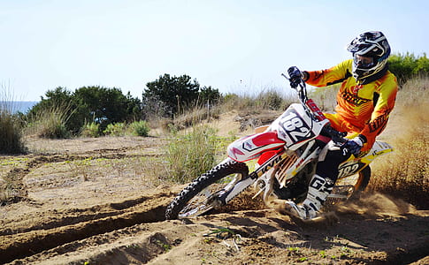person using white and red motocross dirt bike thumbnail