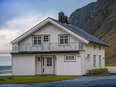 white 2-storey house near mountain and body of water thumbnail