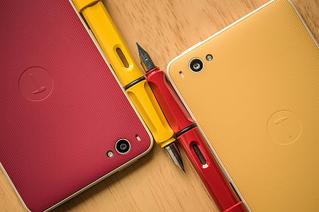 two smartphones beside fountain pens thumbnail