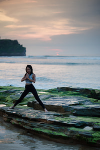 woman doing yoga beside sea under clear blue sky during daytime thumbnail
