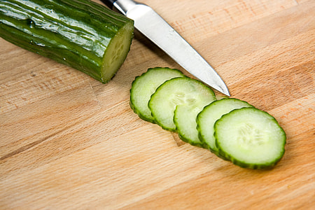 slice of green and white cucumber on brown wooden surface thumbnail
