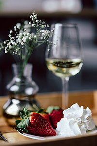 Strawberries with cream and glass of white wine on wooden tray thumbnail