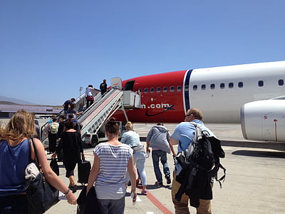 people boarding red and white passenger plane at daytime thumbnail