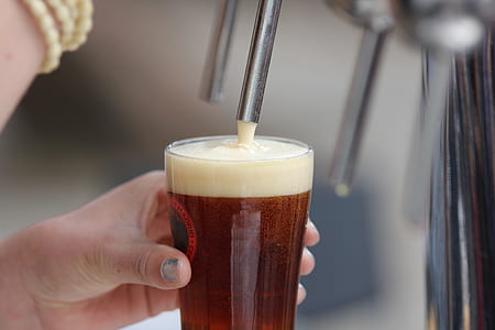 person refiling clear drinking glass with liquid thumbnail