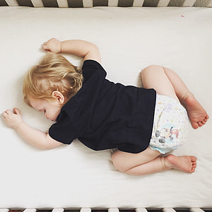baby sleeping on white crib thumbnail