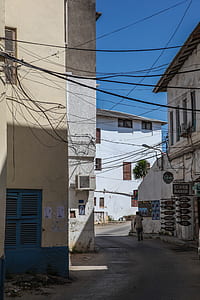 person walking on street between buildings thumbnail