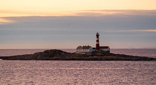 lighthouse surrounded ocean water under gray sky thumbnail