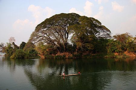 brown boat on body of water near trees at daytime thumbnail