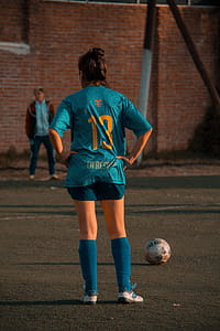 Person In Blue Soccer Jersey Standing In Front Of Ball thumbnail