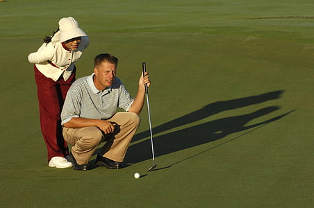 man holding golf club and looking at golf field thumbnail