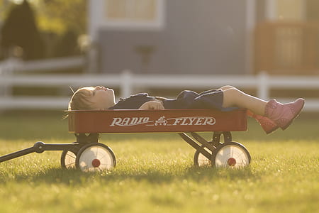 boy laying on red wagon thumbnail