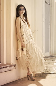 woman wearing white sleeveless tier dress leaning on wall thumbnail