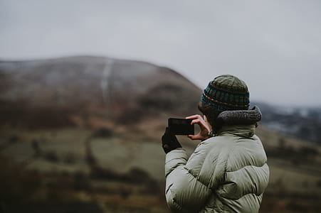 person wearing white bubble jacket using smartphone thumbnail