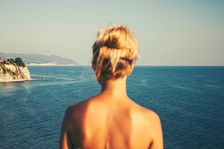 topless person standing near body of water during daytime thumbnail