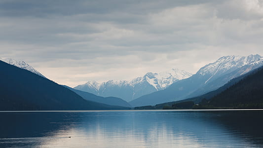 mountain coated with snow near lake during daytime thumbnail