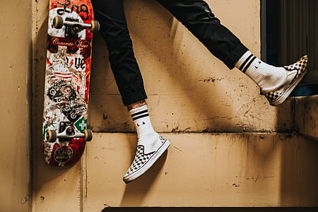 closeup photo of person laying on brown surface beside skateboard thumbnail