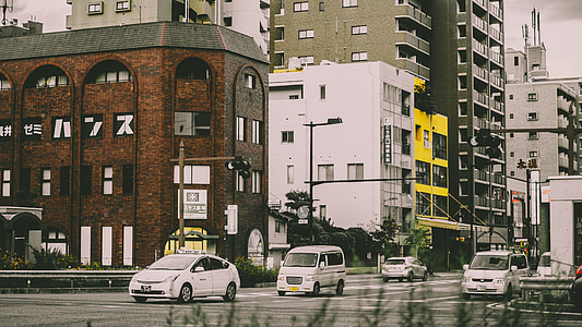 photo of vehicles on road beside buildings thumbnail