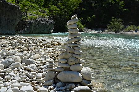 stacked pebbles near body of water thumbnail