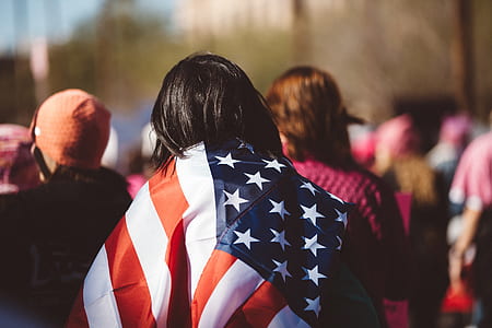 selective focus photography of person carrying flag of United States thumbnail