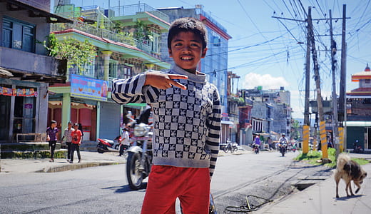 boy wearing gray sweatshirt standing near pavement thumbnail