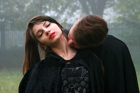 woman wearing black robe while leaning on man wearing black robe during daylight thumbnail