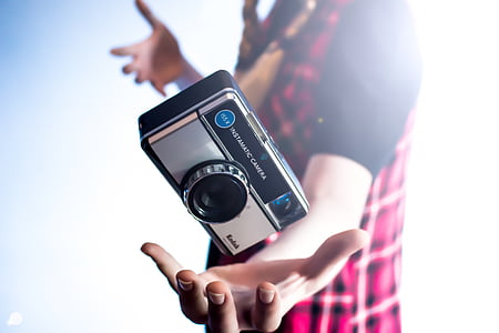 person about to catch black Kodak camera thumbnail