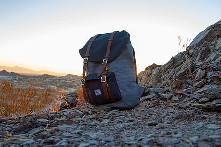gray and black backpack on gray rocks against light at daytime thumbnail