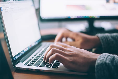person using black and white laptop computer during daytime thumbnail
