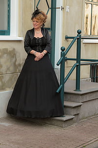 woman standing on concrete stairs while wearing black maxi dress thumbnail