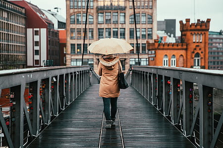A woman holding umbrella walking on the bridge on a rainy day thumbnail