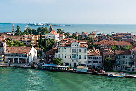 brown and white concrete house near body of water thumbnail