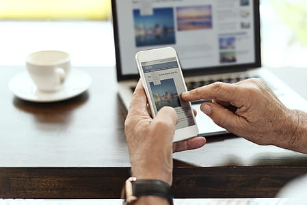 Person Holding Smartphone Sitting Near Table thumbnail