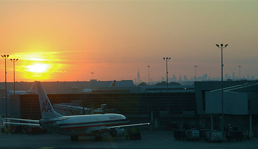 white commercial airliner beside concrete structure thumbnail