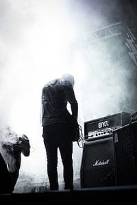 greyscale photo of person standing while playing electric guitar thumbnail