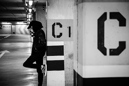 man leaning on white concrete post thumbnail