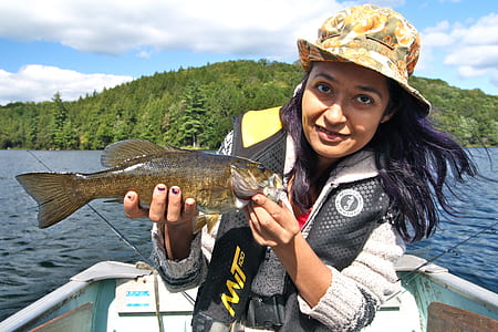 woman holding fresh water fish at the boat thumbnail